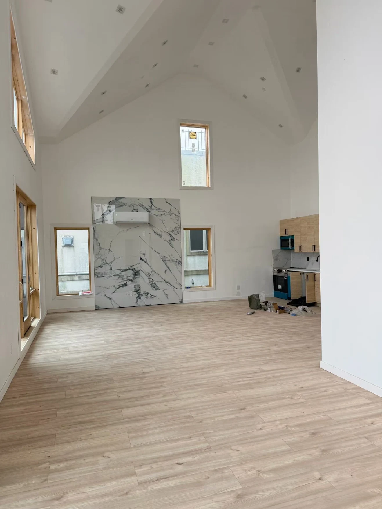 Mini-split indoor unit on a marble feature wall with open kitchen