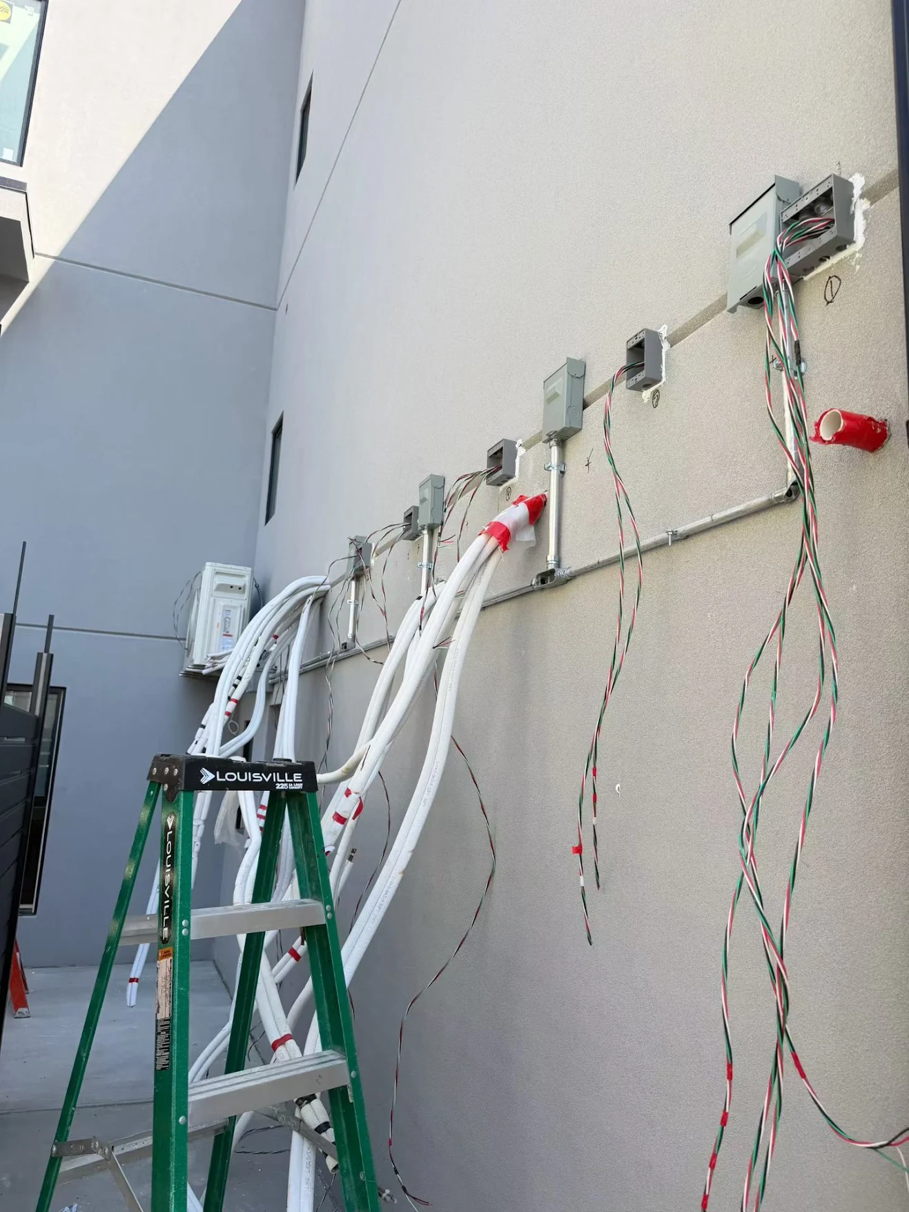 Neatly routed AC refrigerant copper lines and wiring on an exterior wall